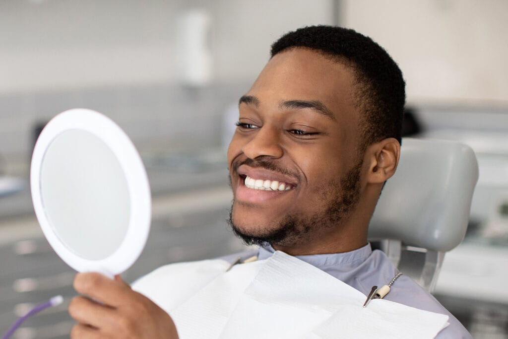 Patient smiling at a mirror