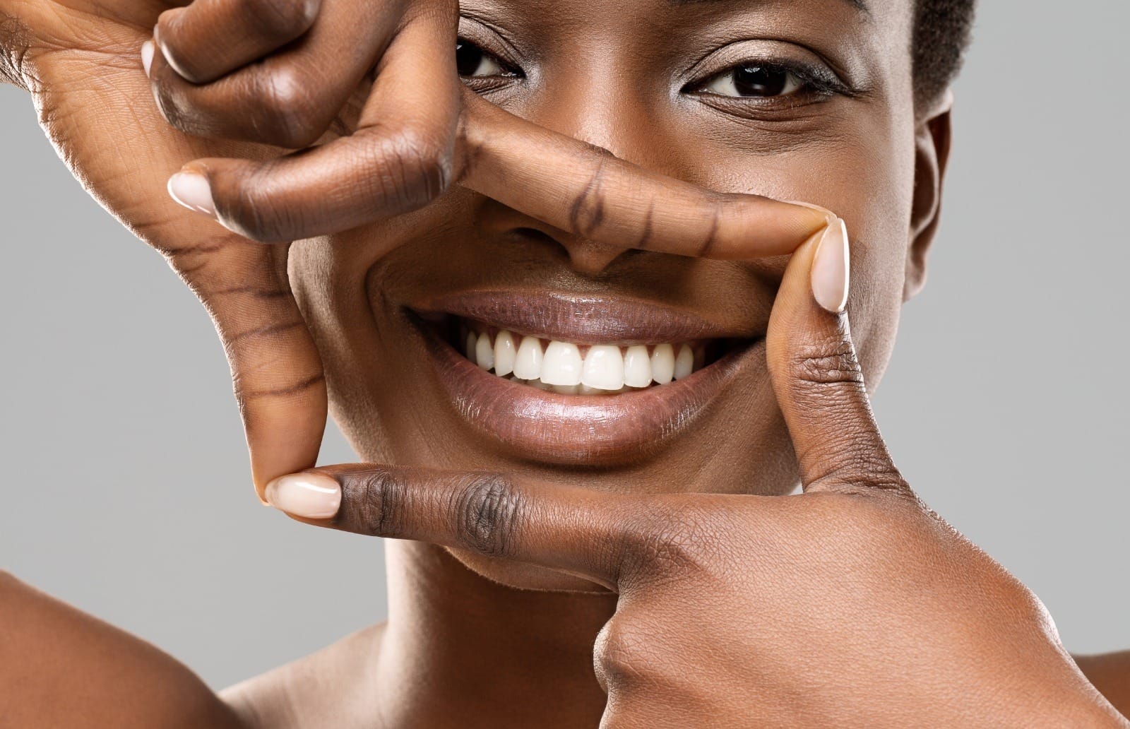 Frame your smile. Beautiful woman framing her perfect white teeth with fingers, closeupFrame your smile. Beautiful woman framing her perfect white teeth with fingers, closeup