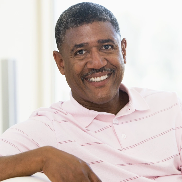 Image of a man smiling in a pink polo shirt.